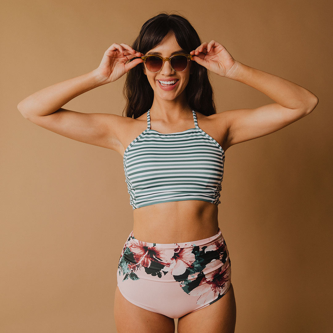 close up of woman wearing pink high waisted swim bottoms with floral design