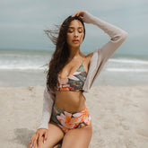 woman on beach wearing floral bralette swim top