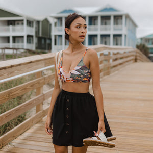 woman wearing bralette swim top with button up skirt