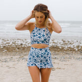 Model holding hair back wearing two piece swimsuit