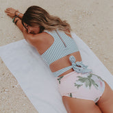 Model laying on beach in Island Fever One-Piece Swimsuit by Albion Fit