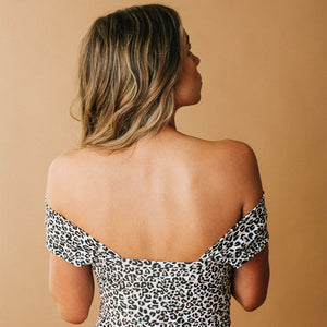 showing a off the shoulder view of a leopard print one-piece swimsuit